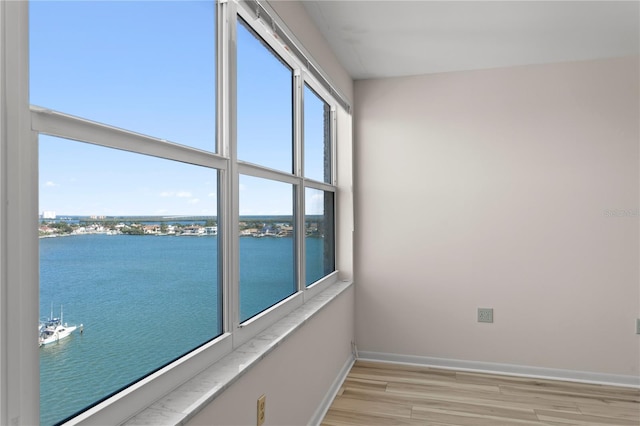 unfurnished room featuring a water view and light wood-type flooring