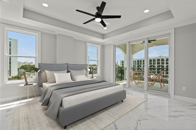 bedroom with ceiling fan, access to exterior, a tray ceiling, and multiple windows