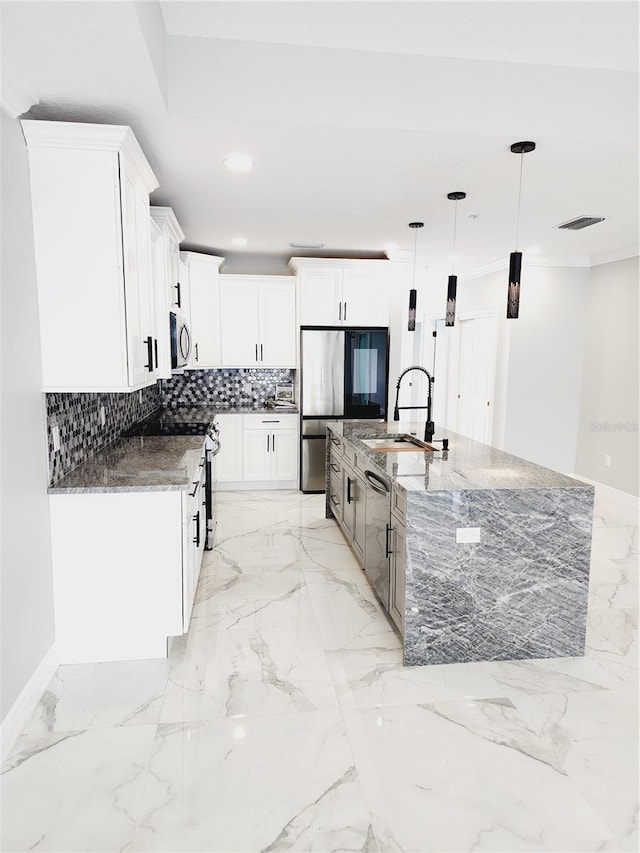 kitchen featuring hanging light fixtures, appliances with stainless steel finishes, dark stone countertops, and white cabinetry