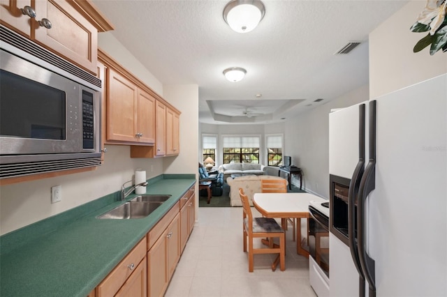 kitchen featuring range with electric cooktop, ceiling fan, sink, white fridge with ice dispenser, and stainless steel microwave