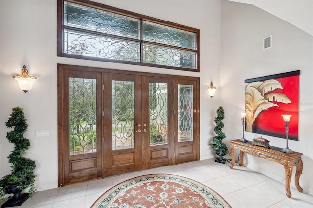 tiled foyer with french doors and high vaulted ceiling