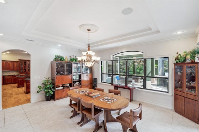 tiled dining room featuring a raised ceiling, a notable chandelier, and ornamental molding