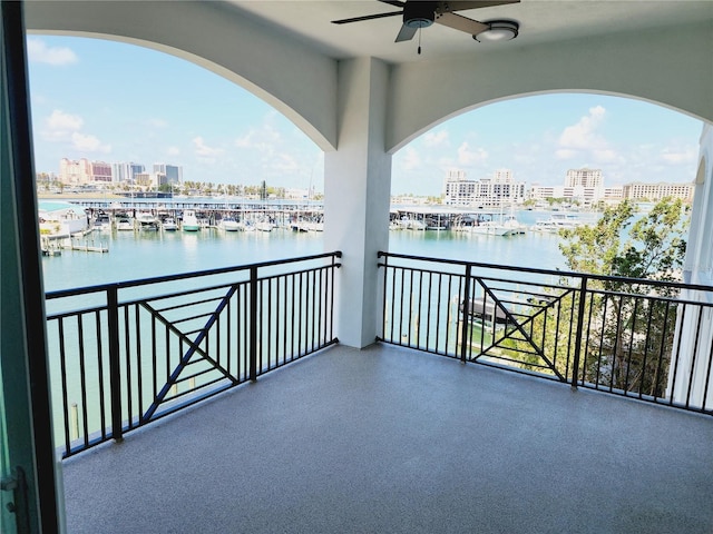 balcony with a water view and ceiling fan