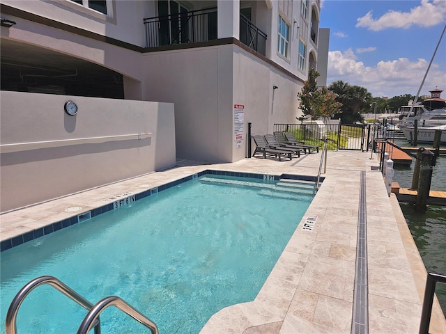 view of swimming pool with a patio area and a water view