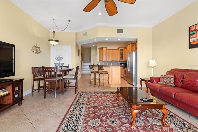 living room with light tile floors, ceiling fan, sink, and crown molding