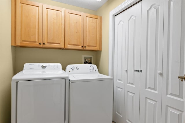 laundry area featuring washer hookup, washing machine and dryer, and cabinets