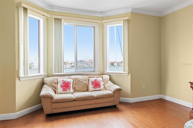 living area with light hardwood / wood-style flooring and crown molding