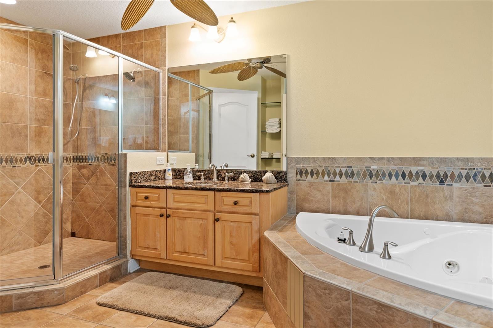 bathroom featuring independent shower and bath, tile flooring, ceiling fan, and vanity