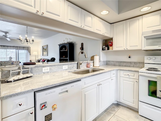 kitchen with white appliances, sink, light tile floors, ceiling fan with notable chandelier, and white cabinetry