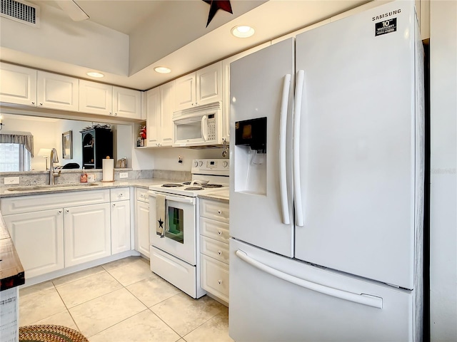 kitchen featuring white cabinets, light tile floors, white appliances, and sink