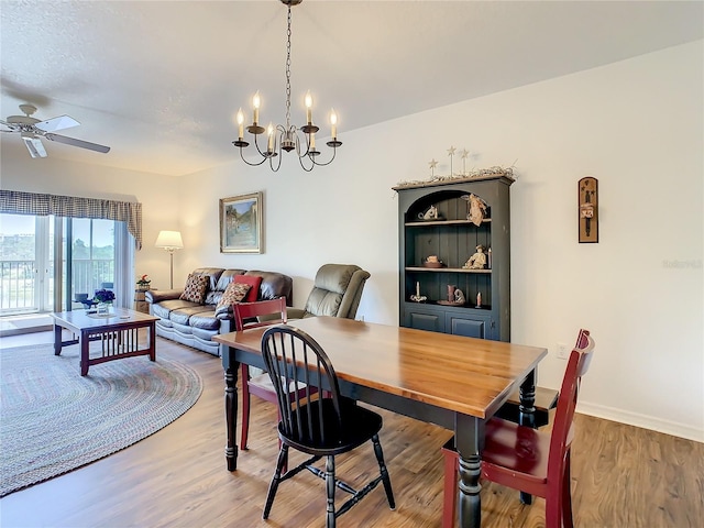 dining room featuring light hardwood / wood-style floors and ceiling fan with notable chandelier