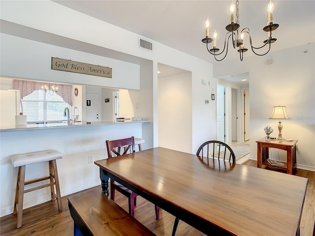 dining space featuring a chandelier and dark hardwood / wood-style flooring