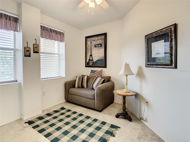 sitting room with ceiling fan and light tile flooring