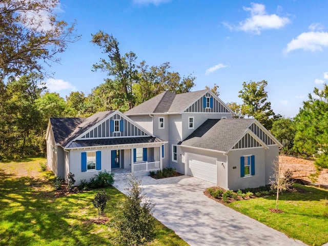 view of front of home with a garage, a porch, and a front yard