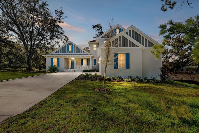 view of front of property featuring covered porch and a lawn