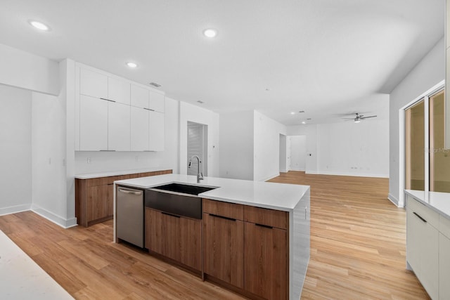 kitchen featuring white cabinetry, sink, an island with sink, and light hardwood / wood-style flooring