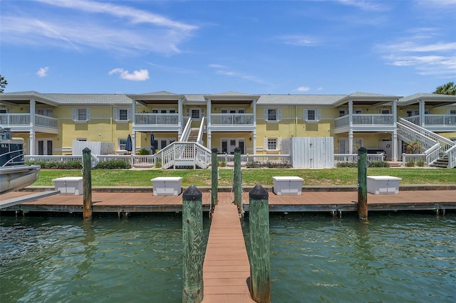 dock area with a balcony and a water view