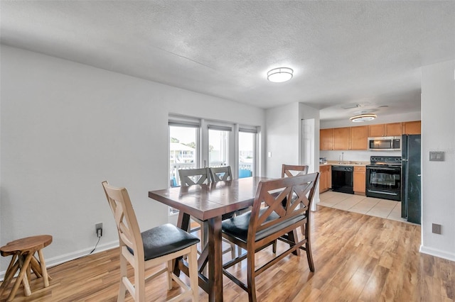 dining area with a textured ceiling and light tile floors