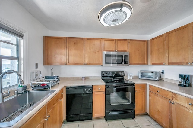 kitchen featuring a textured ceiling, sink, light tile floors, and black appliances