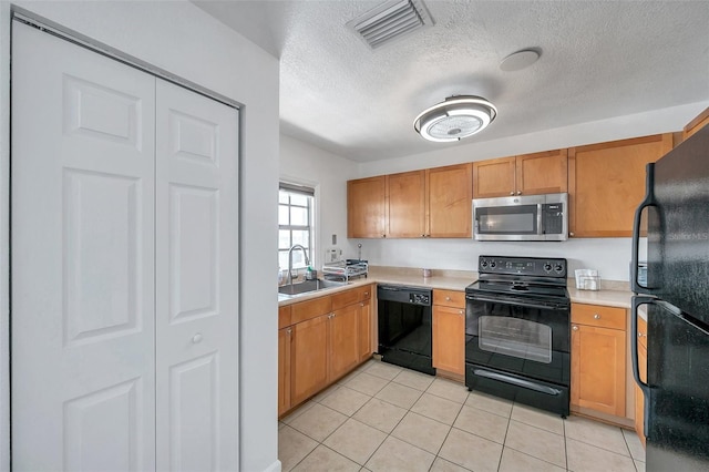 kitchen with a textured ceiling, light tile floors, black appliances, and sink