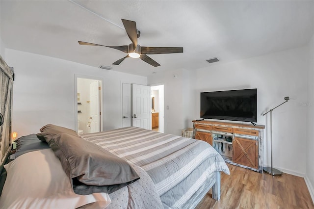 bedroom featuring connected bathroom, ceiling fan, and light wood-type flooring