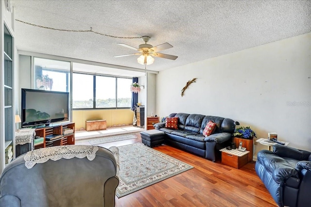 living room featuring a textured ceiling, ceiling fan, and dark hardwood / wood-style floors