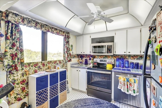 kitchen with light tile floors, appliances with stainless steel finishes, white cabinetry, and ceiling fan