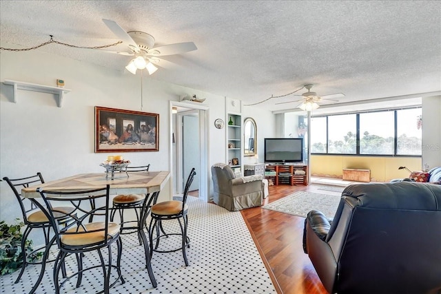 living room featuring dark hardwood / wood-style flooring, a textured ceiling, and ceiling fan