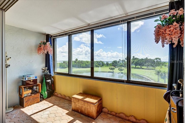 sunroom featuring plenty of natural light and a water view