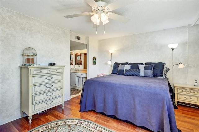 bedroom with dark hardwood / wood-style floors, ceiling fan, and ensuite bathroom