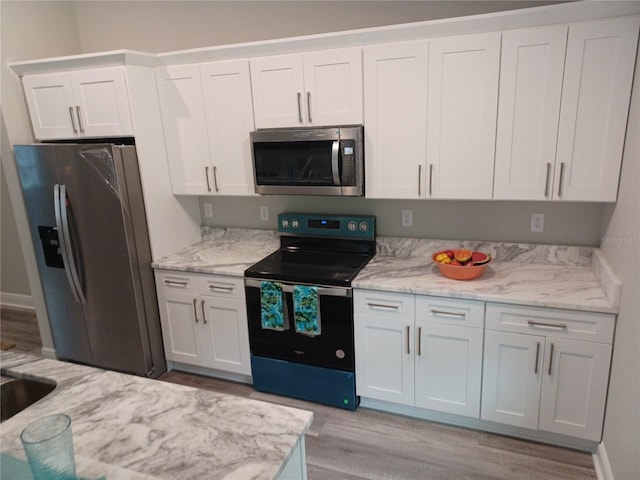 kitchen featuring light hardwood / wood-style flooring, white cabinets, and stainless steel appliances