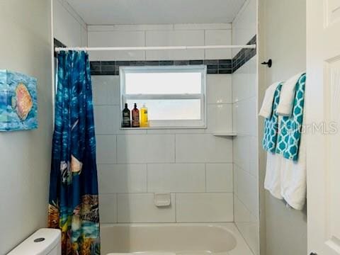 bathroom with shower / bath combo and toilet