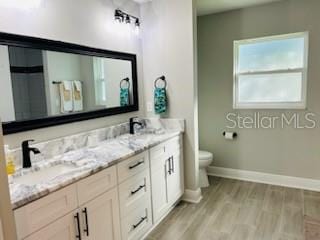 bathroom featuring vanity, hardwood / wood-style flooring, and toilet