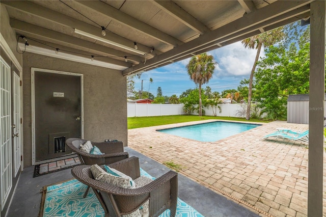 view of swimming pool with a storage shed and a patio area