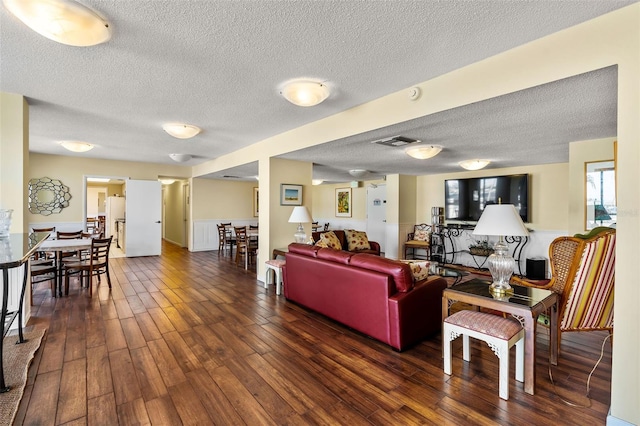 living room with dark wood-type flooring and a textured ceiling