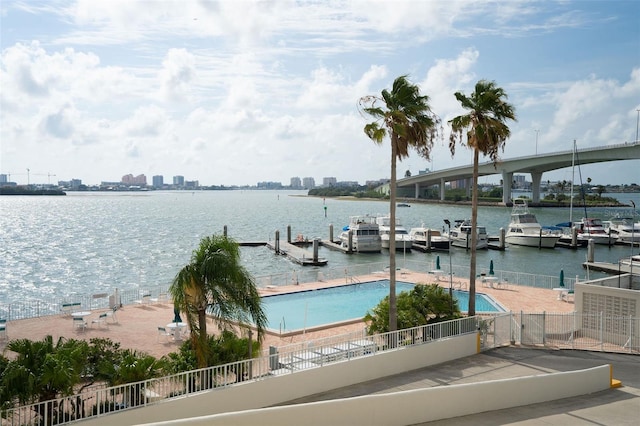 view of dock featuring a community pool and a water view