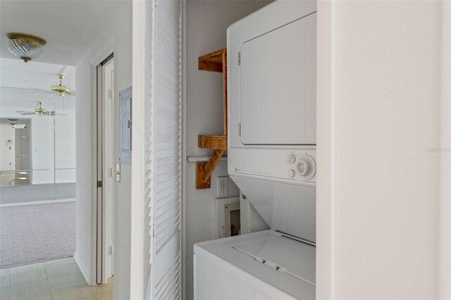 washroom with light tile patterned floors and stacked washer and clothes dryer