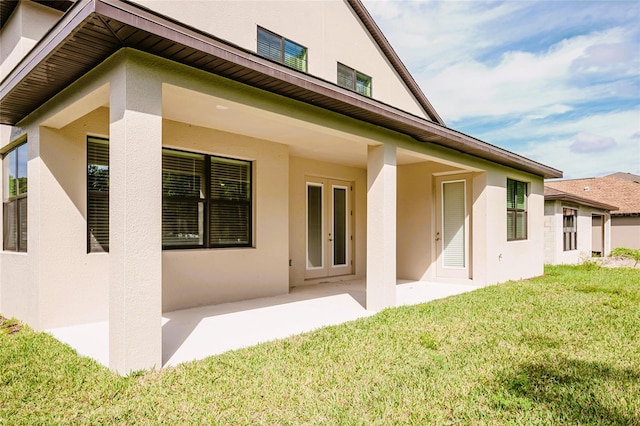 rear view of house with a yard and a patio