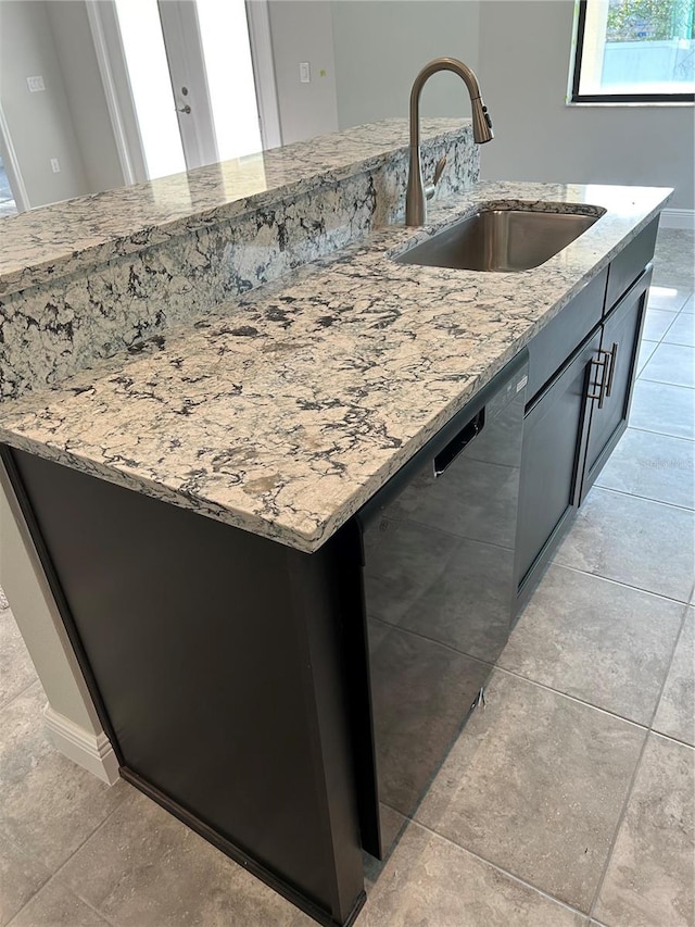 kitchen featuring sink, dishwasher, and light stone countertops