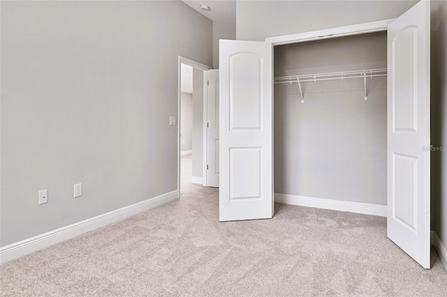 unfurnished bedroom featuring a closet and light carpet