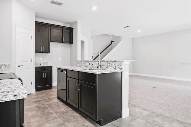 kitchen featuring dishwasher, light carpet, a center island with sink, light stone countertops, and sink