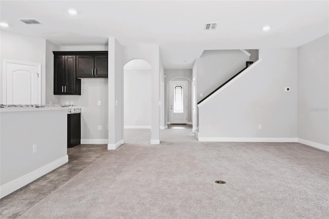 unfurnished living room featuring light colored carpet