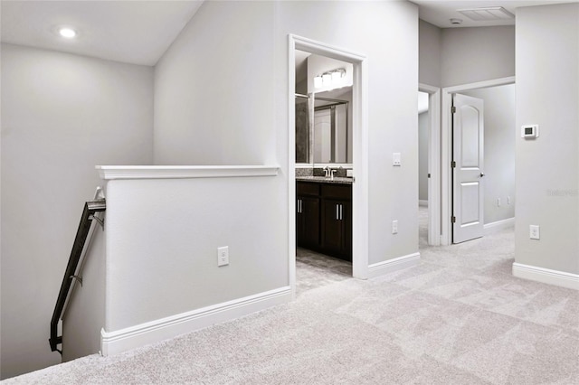 carpeted empty room featuring lofted ceiling and sink