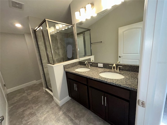 bathroom with a shower with door, tile patterned floors, and vanity