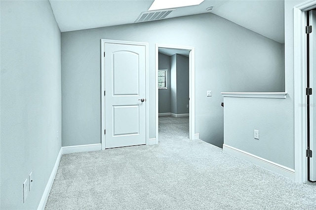 carpeted spare room featuring vaulted ceiling