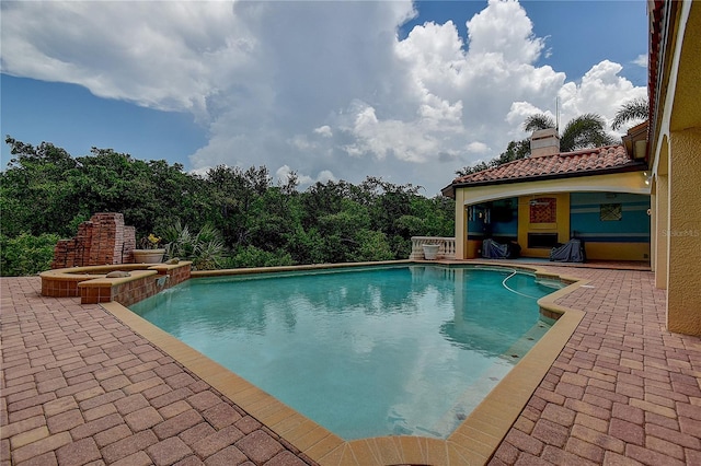 view of swimming pool featuring an in ground hot tub and a patio area