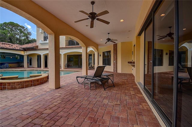 view of patio / terrace with a swimming pool with hot tub and ceiling fan