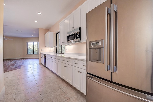 kitchen with white cabinetry, appliances with stainless steel finishes, sink, and light tile patterned floors