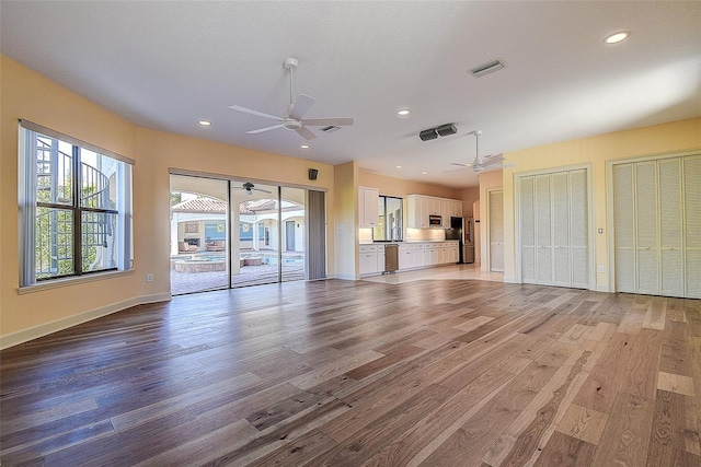 unfurnished living room with ceiling fan and light wood-type flooring