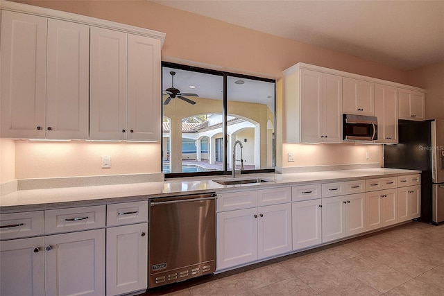 kitchen with sink, white cabinetry, light tile patterned floors, ceiling fan, and stainless steel appliances